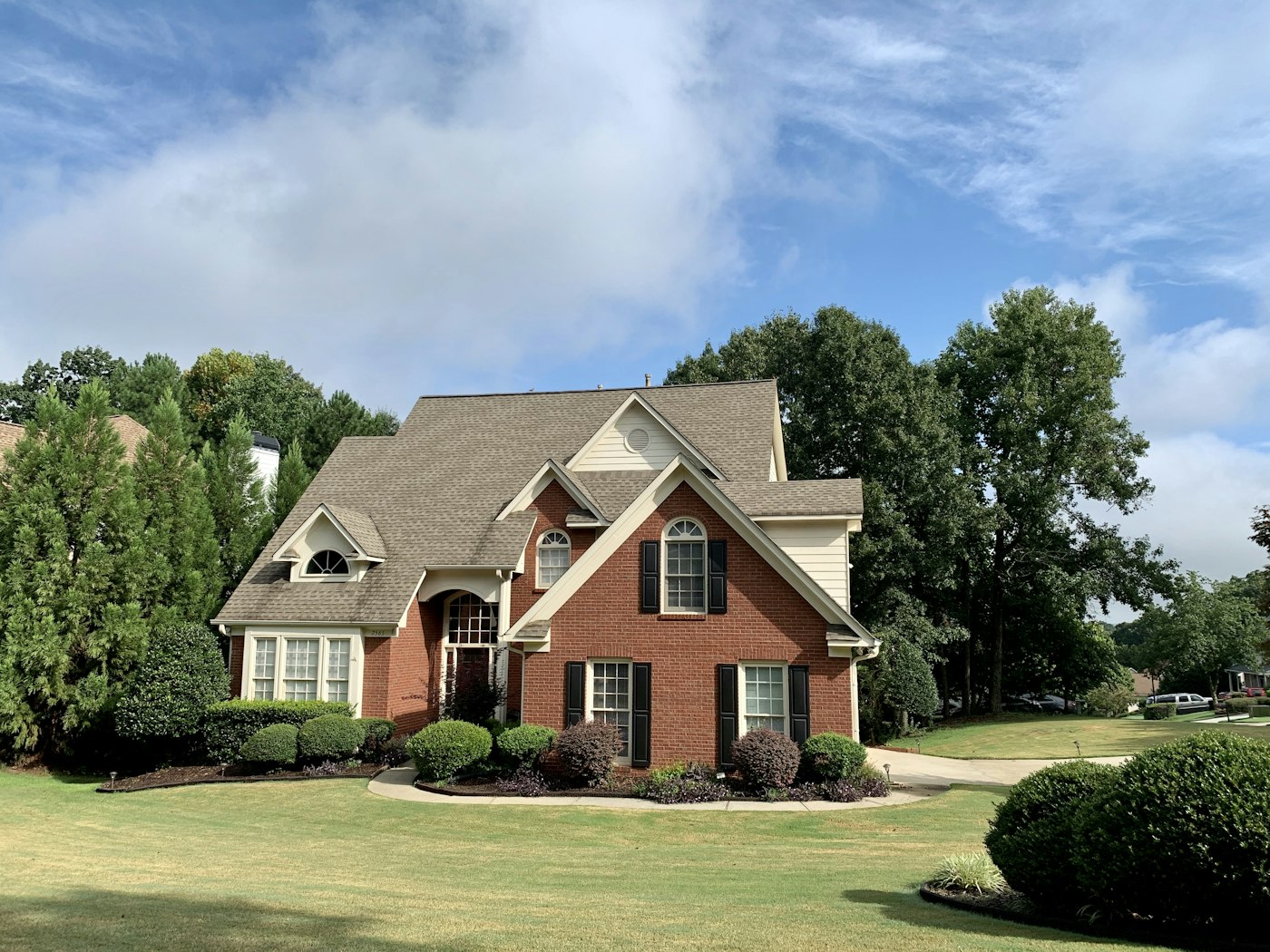 Brick traditional home with manicured lawn